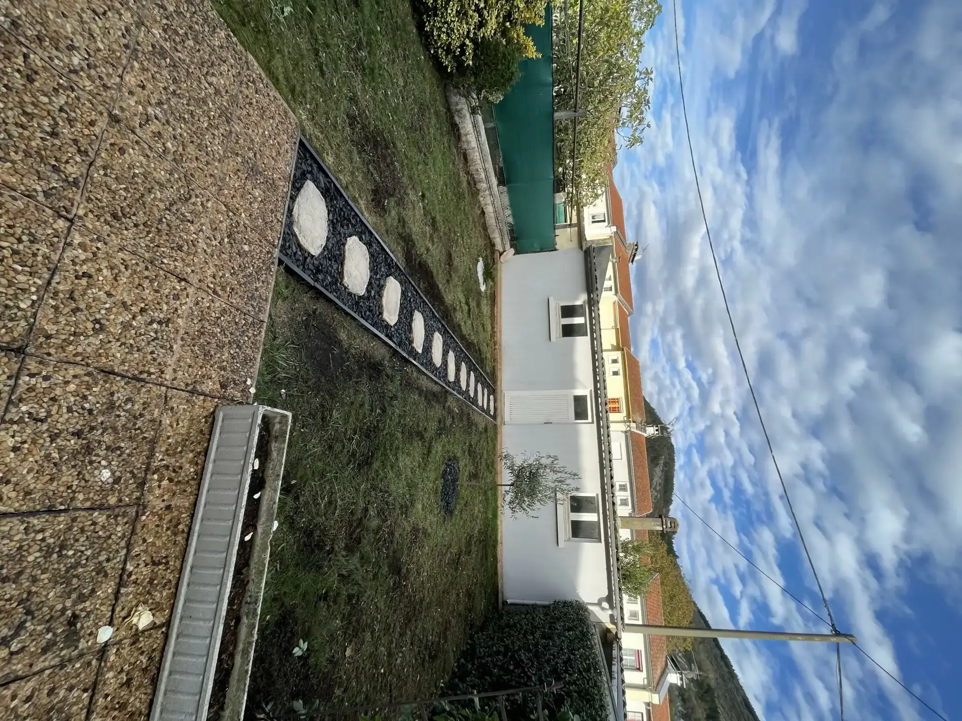 Allée de jardin en pas japonais clairs sur un lit d’ardoise sombre