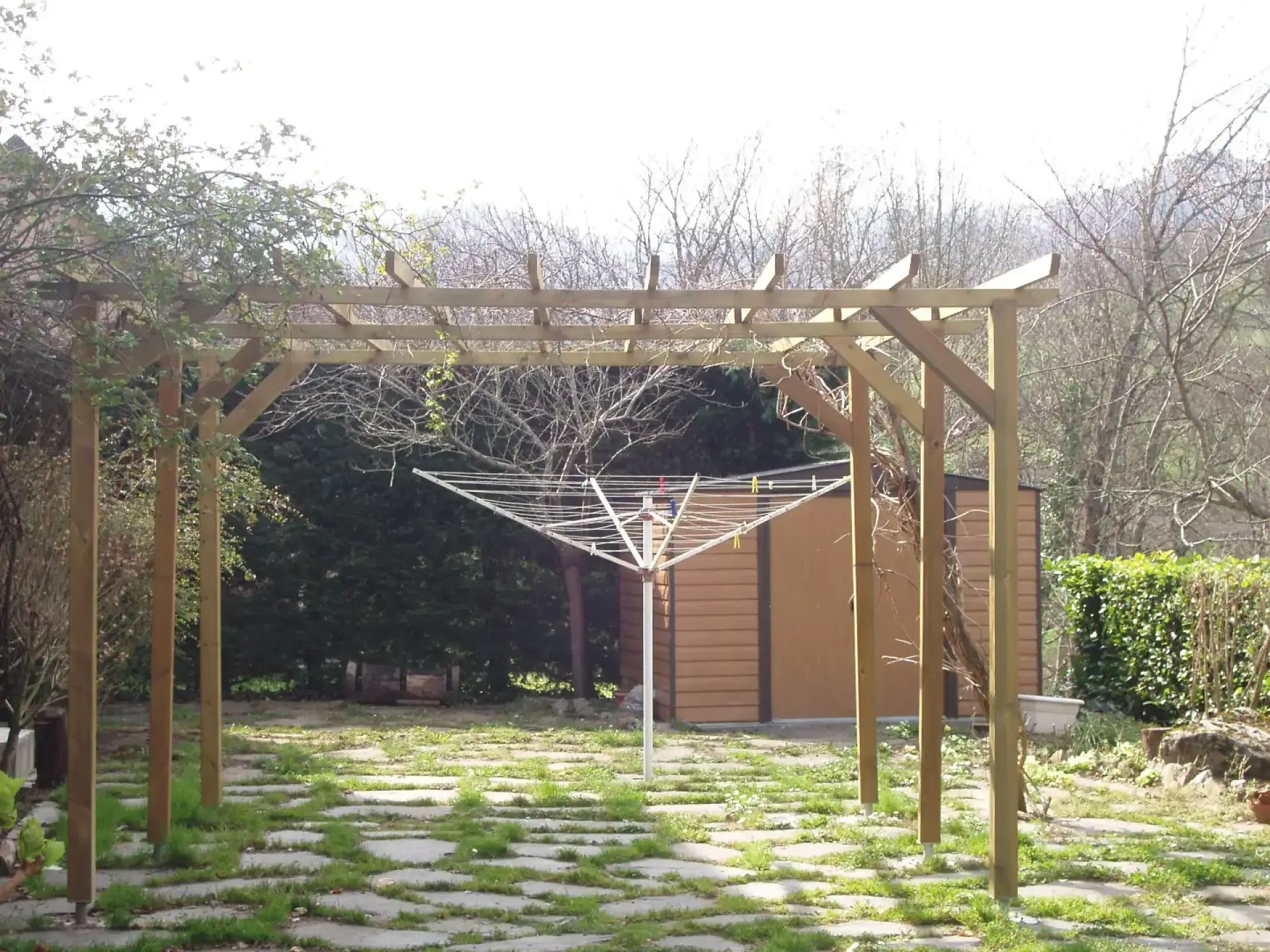 Pergola en bois et dallage dans un jardin paysager