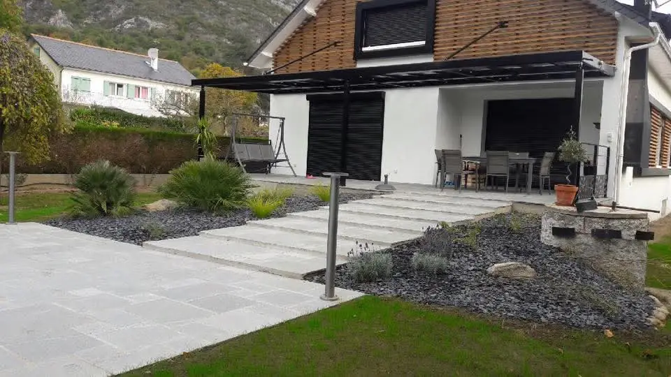 Jardin avec terrasse dallée, escalier et massifs minéraux plantés