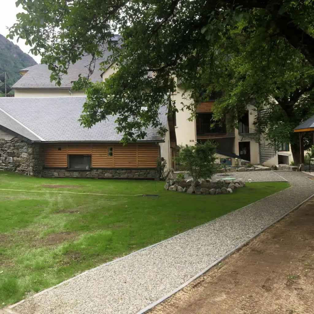 Jardin aménagé avec pelouse, allée gravillonnée et massif minéral
