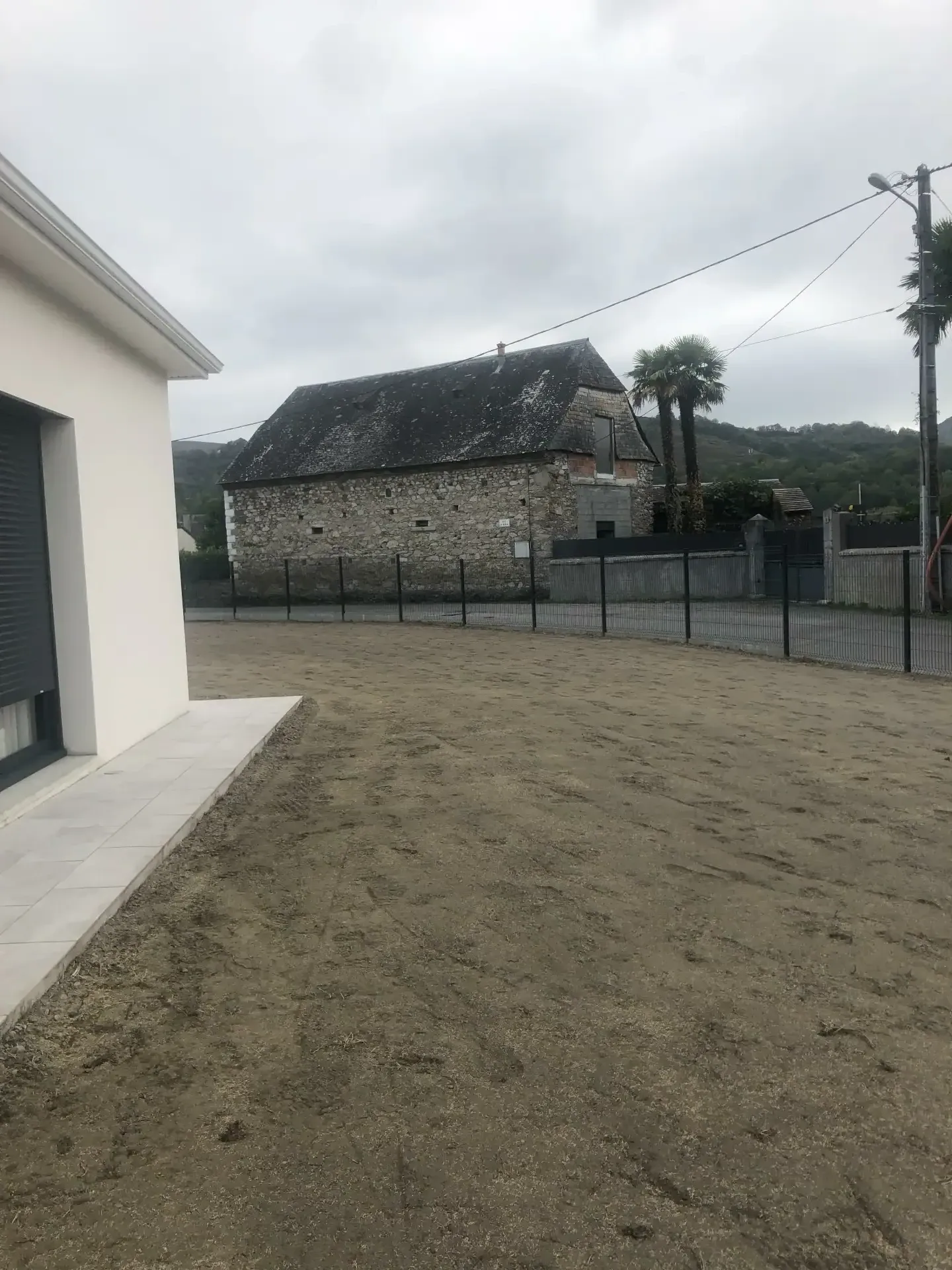 Terrain nu préparé devant une maison pour un futur engazonnement